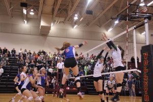 Junior Autumn Lockley goes up for a kill with the rest of the team ready to recover the block